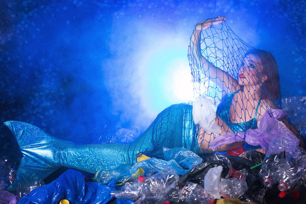 Konzept zur Verschmutzung der Ozeane durch Plastik. Meerjungfrau wegen verschmutztem Lebensraum verängstigt. - Foto, Bild