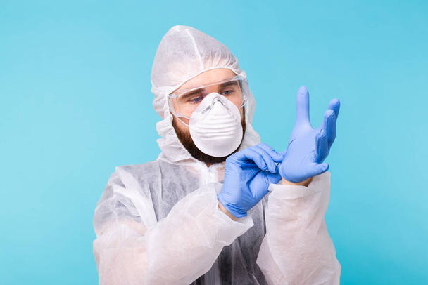 Profesionální pro dezinfekci. Epidemiolog si obléká ochranné obleky a rukavice. Koronavirus, covid-19 a pandemická koncepce. - Fotografie, Obrázek