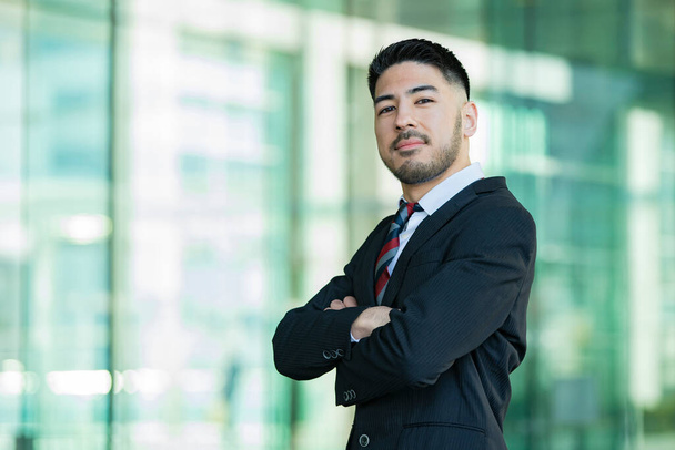 Mixed race young businessman with beard in suit standing outdoors - Φωτογραφία, εικόνα