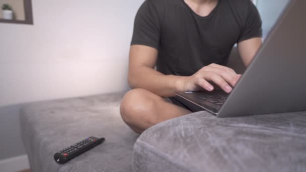 Mann, der mit Laptop zu Hause arbeitet, arbeitsreiches Wochenende, Internetverbindung, wfh neuer normaler moderner Lifestylemann, der auf Tastatur tippt, Selbstquarantäne covid-19, abgelegenes Sofa-Sitzen, häusliches Leben - Filmmaterial, Video