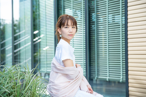 Asiatica (giapponese) giovane donna che riposa all'aperto con un sorriso gentile
 - Foto, immagini