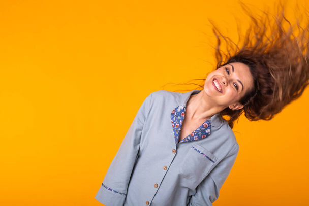 Χαριτωμένη και χαρούμενη γυναίκα κουνώντας τα μαλλιά στο στούντιο lifestyle κίτρινο φόντο συναισθήματα. Αντιγραφή χώρου. - Φωτογραφία, εικόνα