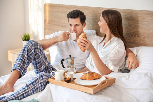 Manhã do jovem casal tomando café da manhã na cama
 - Foto, Imagem
