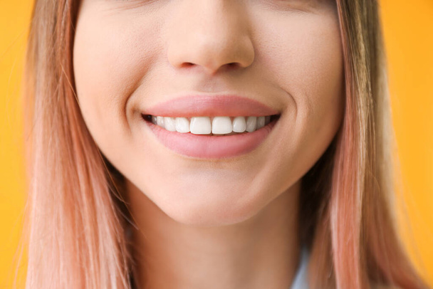 Young woman with healthy teeth on color background, closeup - Foto, afbeelding