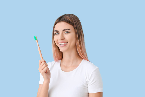Beautiful young woman with toothbrush on color background - Foto, imagen