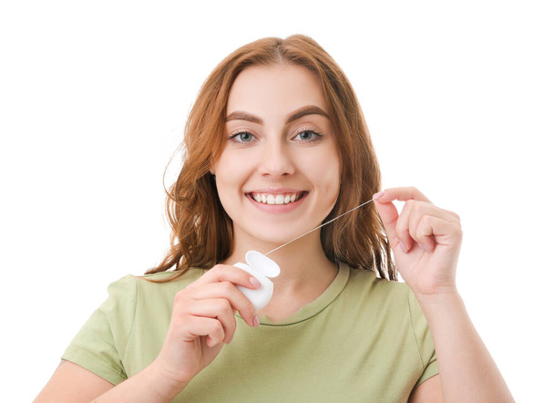 Beautiful young woman with dental floss on white background - Photo, Image