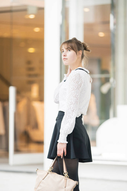 Blanke jonge vrouw wandelen op een winkelstraat in Shibuya, Tokio - Foto, afbeelding