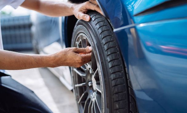 Maintenance male checking and removing tire valve filling nitrogen service on street at gas station, Safety vehicle to reduce accidents before a long travel, Blue car of man transportation lifestyle   - Foto, imagen