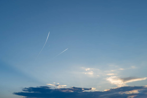 Aviones lejanos y senderos de vapor volando alto en un cielo azul claro
 - Foto, imagen