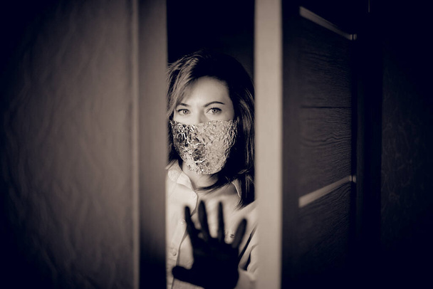 Meisje in quarantaine thuis met masker en handschoenen in maart 2020 - Foto, afbeelding