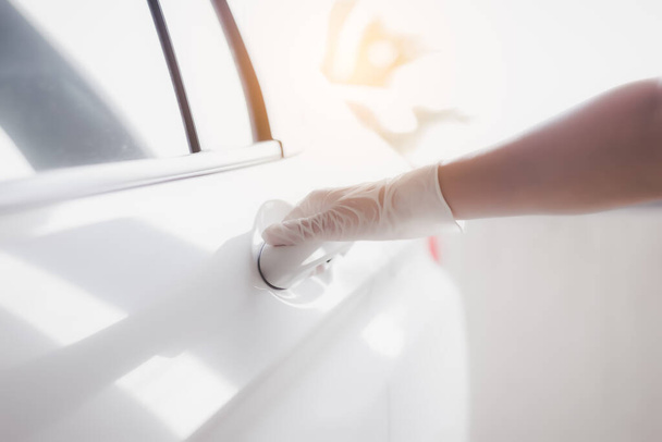 Medical gloves. Women wear protective glove for protecting infected of covid 19, coronavirus, flu virus or germs. She opening the car door by holding handle. Medical glove protect viruses for infected - Foto, Imagen