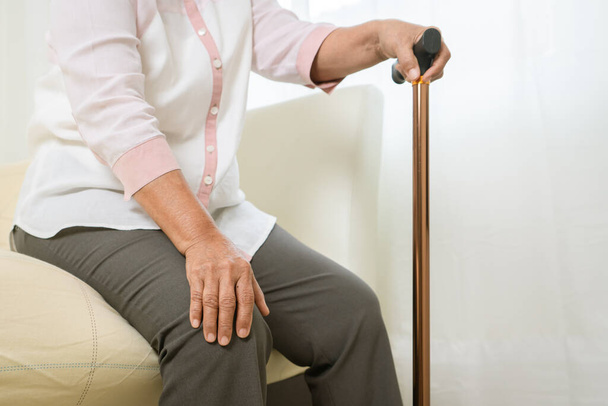 Dolor de rodilla de la mujer mayor con palo, problema de salud del concepto senior
 - Foto, Imagen