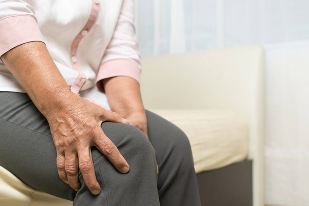Knee pain of old woman at home, healthcare problem of senior concept - Photo, Image