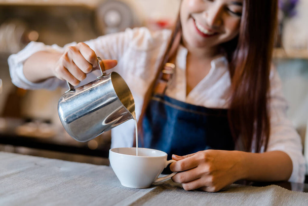 Professional Asian woman Barista preparing coffee at front counter serving coffee cup to customer occupation, part-time,job or owner business working woman happy selling and making drink beverage - 写真・画像