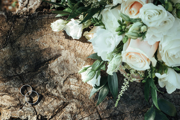 Bridal bouquet near rings on a stump - Foto, immagini