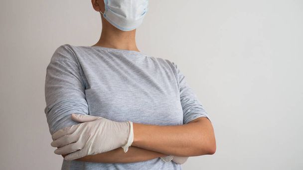 Female doctor or nurse with surgical mask and medical gloves. Negative space. Copy space for text. - Фото, изображение