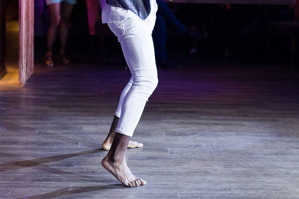 Dancing shoes feet and legs of male ballroom and latin salsa dancer dance teacher on the stage. Social dance, bachata solo and kizomba concept - Photo, Image