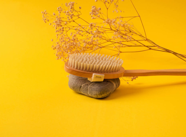 Zero waste dry massage wooden brush on yellow - Foto, afbeelding