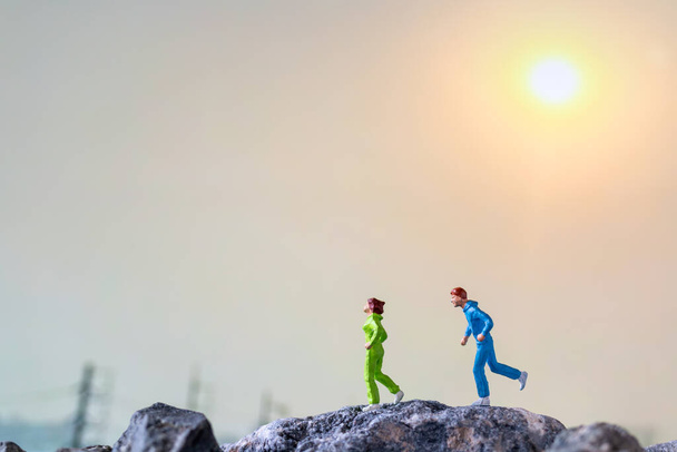 Persone in miniatura: Correre su una scogliera rocciosa con sfondo naturale, Salute e stili di vita concetti
 - Foto, immagini