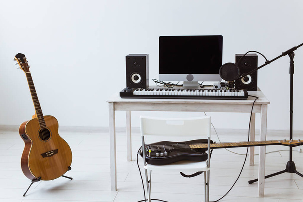 Microphone, computer and musical equipment guitars and piano background. Home recording studio concept. - Photo, Image