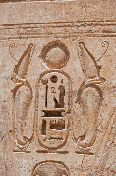 Hieroglypisch houtsnijwerk op de muur bij de oude Egyptische tempel van Medinat Habu in Luxor - Foto, afbeelding