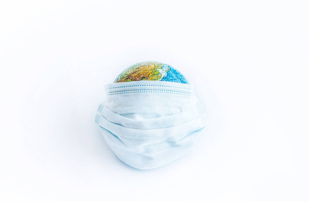 Earth planet in protective medical mask Isolated on white background. Novel rapidly spreading Coronavirus, 2019-nCoV pandemic. - Foto, Imagem