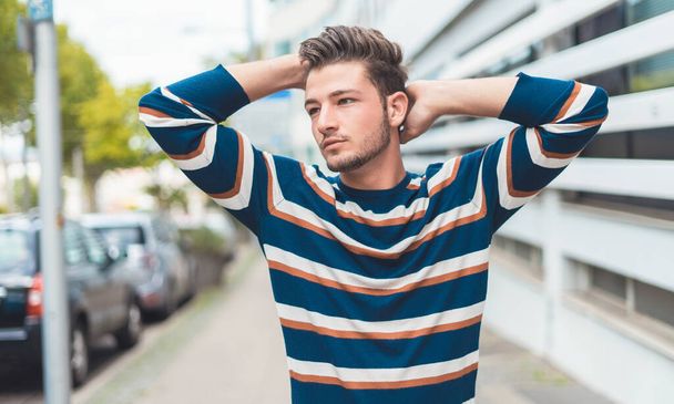Young beautiful man posing in the street. Guy with modern hairstyle, outdoor - Foto, afbeelding
