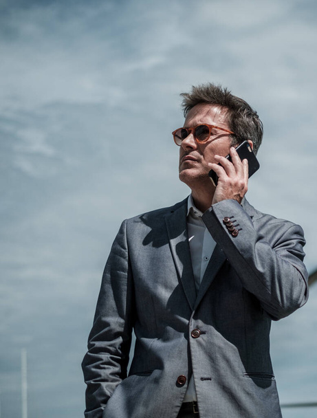 Homme d'affaires avec un téléphone sur un terrain d'aviation
 - Photo, image