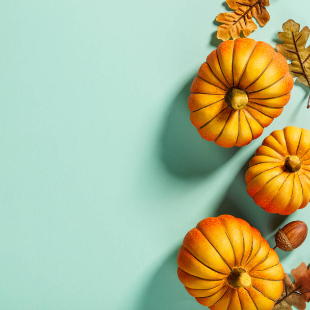 Herbst Hintergrund kreative Gestaltung mit dekorativen kleinen Kürbissen und Herbstblättern. Flach auf blauem Hintergrund, Kopierraum von oben - Foto, Bild