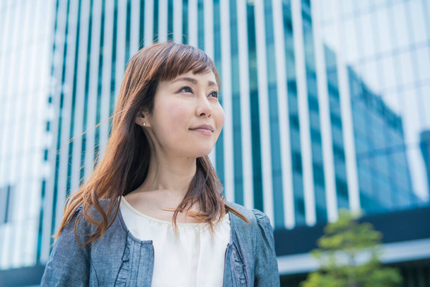 Porträt einer lächelnden asiatischen (japanischen) Geschäftsfrau an sonnigen Tagen im Freien - Foto, Bild