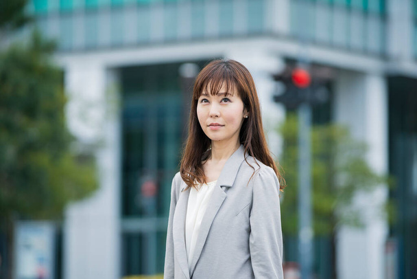 Retrato de una sonriente mujer de negocios asiática (japonesa) al aire libre en un día soleado
 - Foto, Imagen