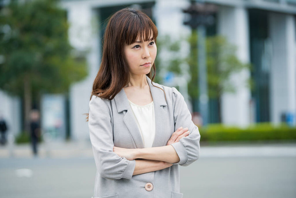 Eine asiatische (japanische) junge Angestellte mit beunruhigendem Gesichtsausdruck - Foto, Bild