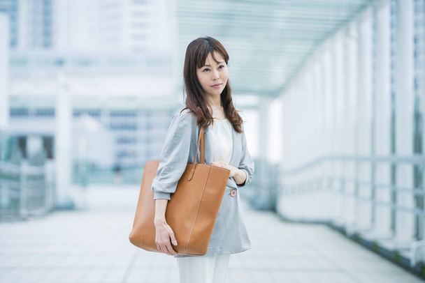 Asiatico business donna pendolarismo a affari distretto in affari casual vestiti
 - Foto, immagini