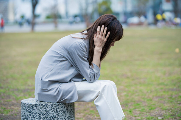 Asiático pessoa de negócios sofrendo de dor de cabeça devido ao estresse nos negócios
 - Foto, Imagem