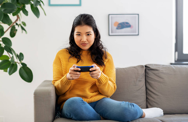 asian woman with gamepad playing game at home - Фото, зображення