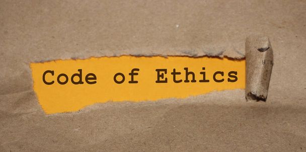 Texto que aparece atrás de envelope marrom rasgado - Código de ética. - Foto, Imagem