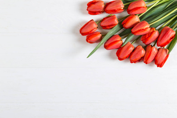 Red tulips on white table, background frame, text blank. Copy space. - Photo, image