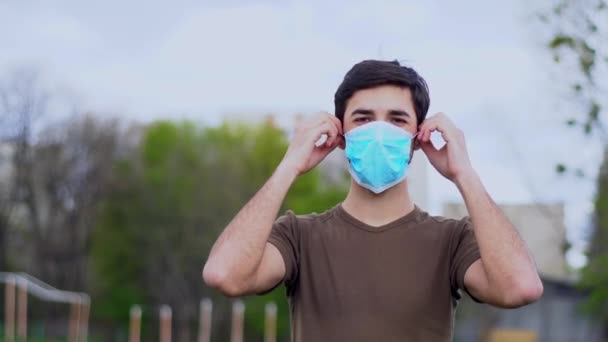 ハンサムな若い男の白人は彼の顔から医療マスクを削除します。コロナウイルス流行概念. - 映像、動画