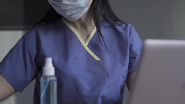 Doctor working on patients data using laptop - Кадри, відео