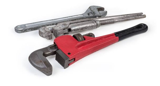 Chiave moderna per tubi pesanti contro le altre chiavi regolabili utilizzate per lavori idraulici su sfondo bianco, primo piano a fuoco selettivo
 - Foto, immagini