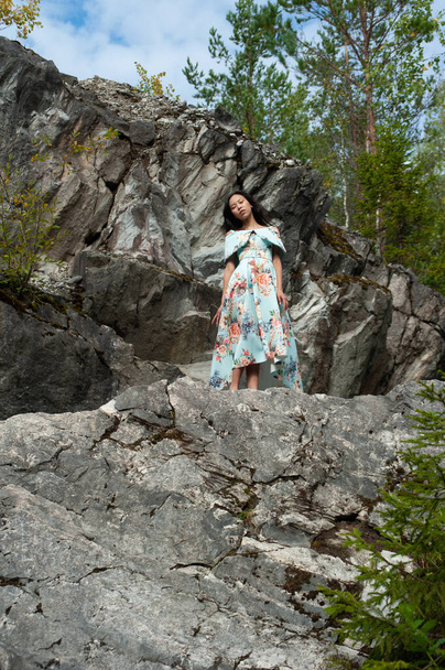 Mladá žena v krásných šatech na kamenech v parku - Fotografie, Obrázek