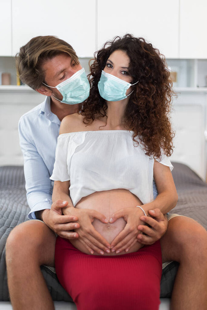 Husband holding pregnant belly's wife - Фото, зображення