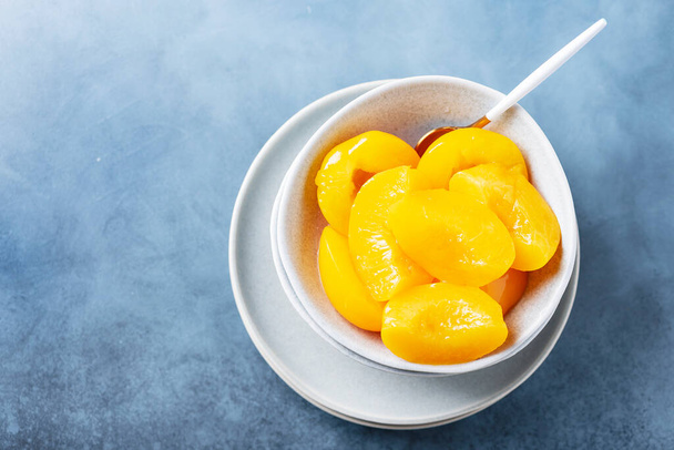 Sweet canned peaches in the ceramic bowl, selective focus image - Фото, зображення