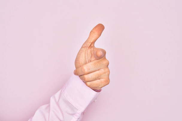 Mano di giovane caucasico che mostra le dita su uno sfondo rosa isolato puntando l'indice verso la fotocamera, scegliendo e indicando verso la direzione
 - Foto, immagini