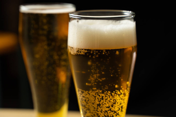 Nahaufnahme von Bechern mit Bier auf schwarzem Hintergrund - Foto, Bild