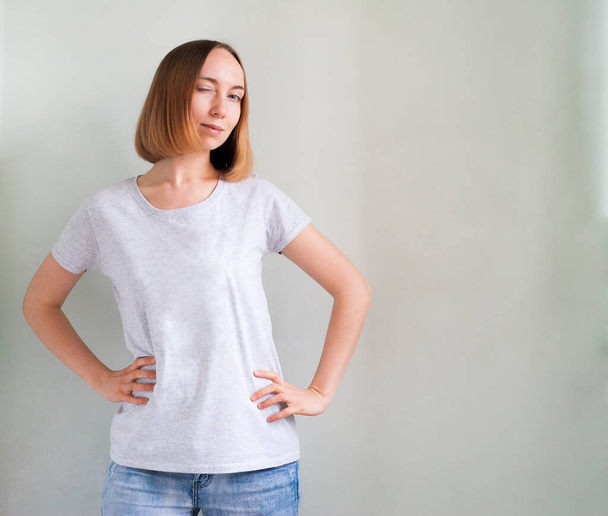 Chica en una camiseta gris sobre un fondo blanco
 - Foto, Imagen