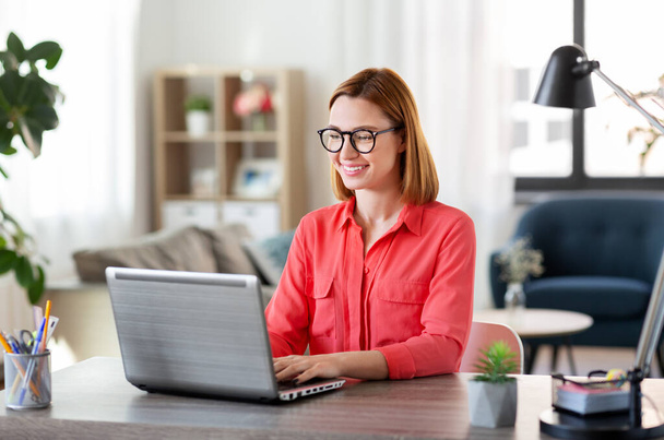 happy woman with laptop working at home office - Φωτογραφία, εικόνα