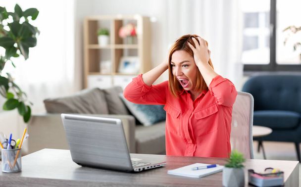 rozzlobená žena s notebookem pracuje na domácí kanceláři - Fotografie, Obrázek