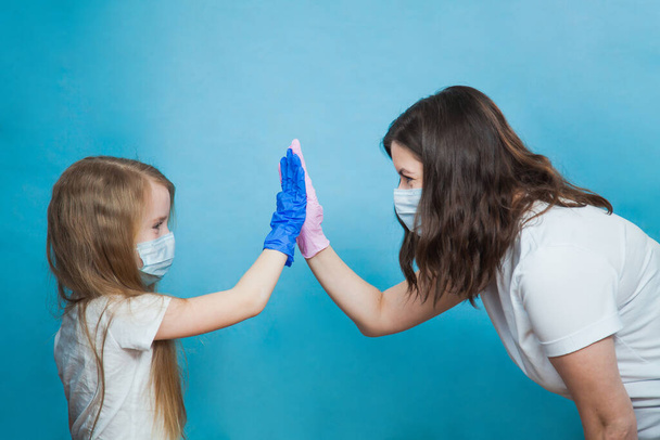Maskeli ve koruyucu eldivenli anne ve kız beşlik çakın. - Fotoğraf, Görsel