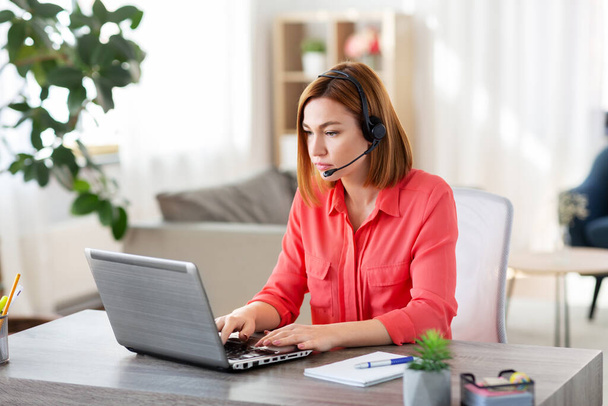 mujer con auriculares y laptop trabajando en casa
 - Foto, Imagen